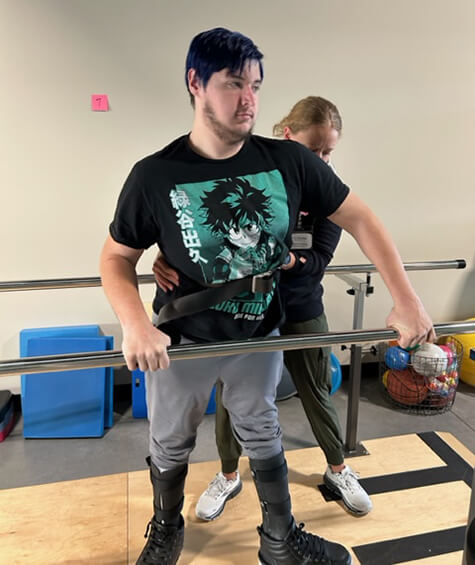 Michael Wall and his therapist working on the parallel bars