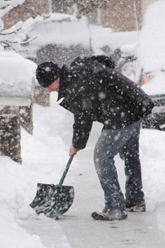 Man shoveling snow from a sidewalk.