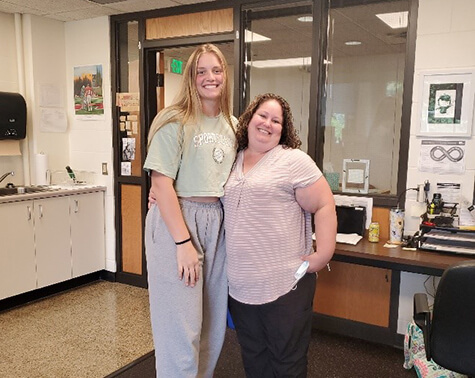 Emma and her Physical Therapist, Corinne, standing together and smiling.