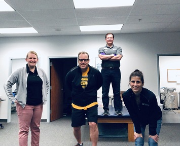 Matt and his therapy team standing in the therapy gym.