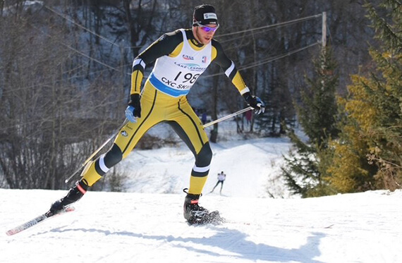 Action shot of Tom outside cross-country skiing in a black and yellow outfit